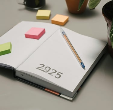 a notebook with a pencil and a pen on a desk