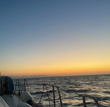 a boat is sailing on the ocean at sunset