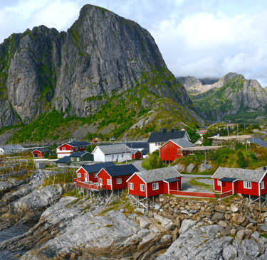a mountain range with a red house and a mountain in the background