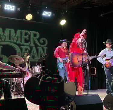 Country musician SUmmer Dean playing her acoustic guitar on stage