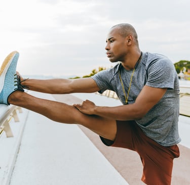 a man in a gray shirt is stretching his legs