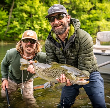 Head guide John Stunkard stands with Joe as they capture a new personal best brown trout.