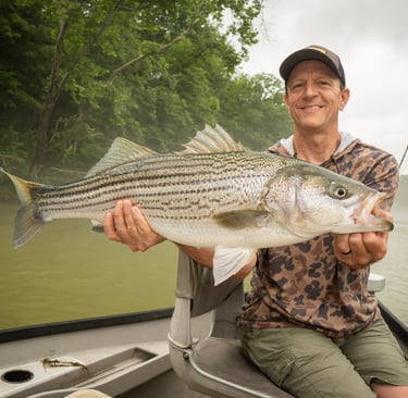 Eric with 1 of 3 striped bass caught on the fly rod