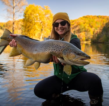 A beautiful female angler with a huge brown trout.