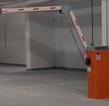 Automatic folding arm barrier gate installed in an underground parking garage for access control.
