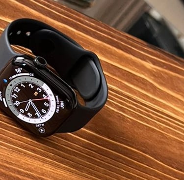 Close-up of a sleek, modern smartwatch resting on a wooden table.