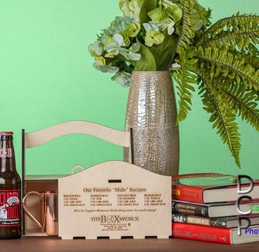 Lifestyle display featuring a custom wooden box for carrying smaller products. Set includes green background with books.