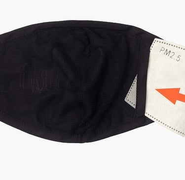 Black Covid face mask showing a replaceable, and disposable filter being inserted.