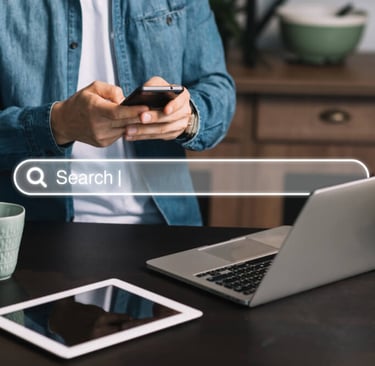 Persona buscando en Google desde móvil y portátil, concepto de SEO en Sabadell