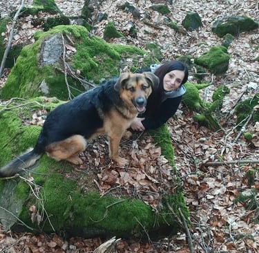 Kobieta z psem siedząca na kamieniu