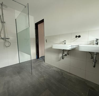 ein renoviertes Bad mit hellen und dunklen Fliesen