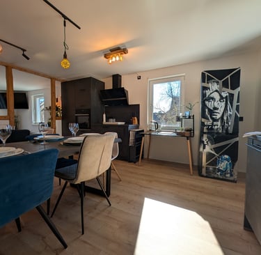 eine moderne, sanierte, schwarze Küche mit hellem Vinylboden und Fachwerk