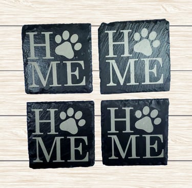a set of four slate coasters engraved with the word home.