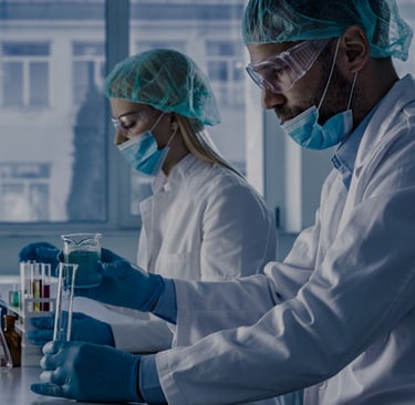 two people in lab coats and masks on a lab