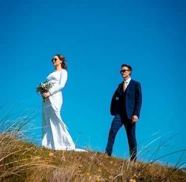 a bride and groom walking down a hill