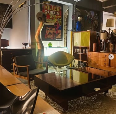 Salle d'exposition moderne du milieu du siècle avec des tables basses vintage, des fauteuils rétro e