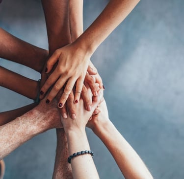 Manos unidas simbolizando el apoyo social y la conexión emocional que fortalece la amistad.