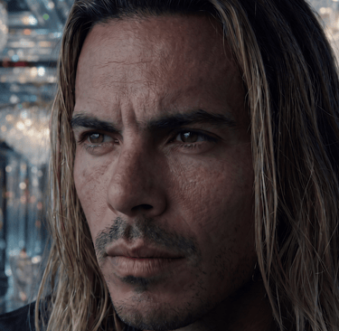 Close-up portrait of a long-haired man in a luxurious crystal ballroom with chandeliers.