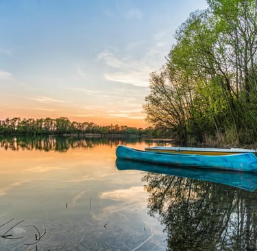 a blue boat on the water at sunset