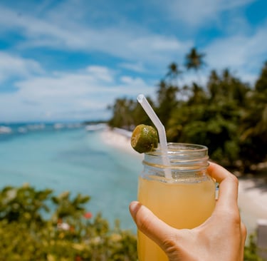 a person holding a drink in a mason jar