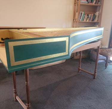 a harpsichord case sitting on top of a carpet