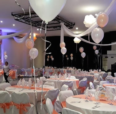 a room with many tables and chairs and balloons