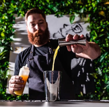A bartender preparing a cocktail with various drinks 