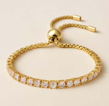 Gold adjustable bracelet with clear gemstones on a light background