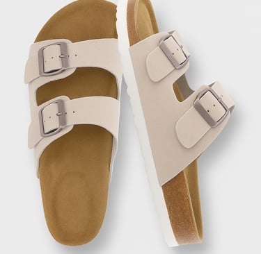 Beige double-strap slide sandals with cork soles on a light background
