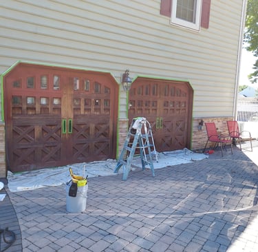 a drive way a car and ladders around garage