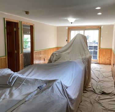 a room with drop clothes covering furinture
