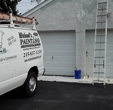 a van in a driveway with ladders on a garage