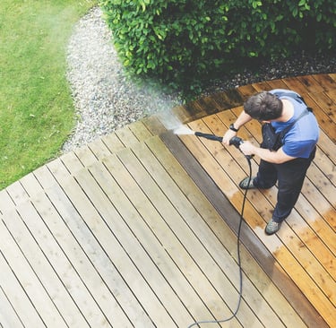 a man is using a pressurer washer to clean a deck