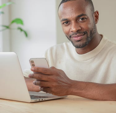 a man sitting at a table with a cell phone in his hand