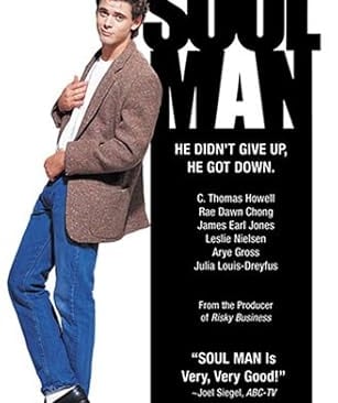 a man in a suit and jeans standing in front of a poster