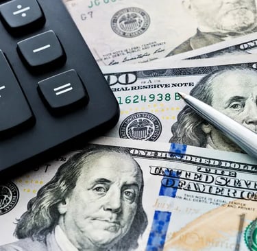 alt="Calculator and pen on top of hundred dollar bills representing business loan brokering and funding support"