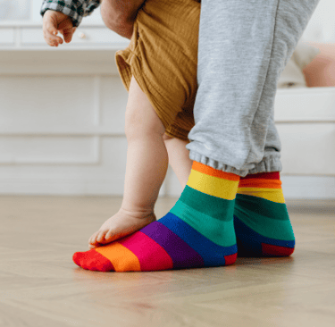 Adult feet with baby feet standing on top of them