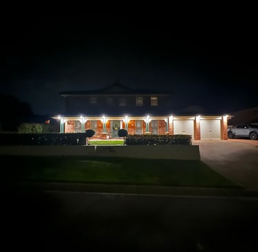a house lit up outside by downlights 