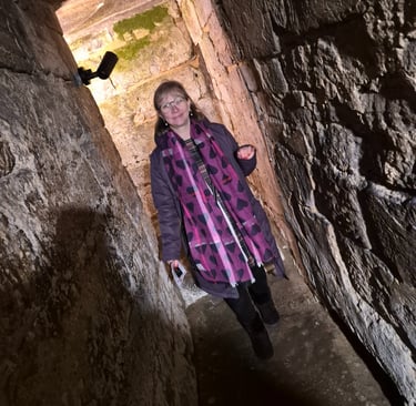 Penelope Jane wandering through a narrow stone passage in the crypt beneath Hexham Abbey