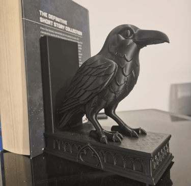 Serre-livres corbeau noir imprimé en 3D soutenant un livre sur une étagère