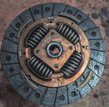 Close-up view of a metal automotive clutch disc showing the friction plate and springs.