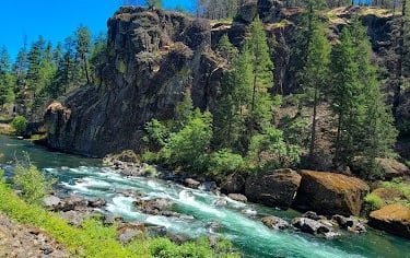 Waterfall Hwy, OR - Dark mountainous boulders, lush green trees, and a dazzling aqua river