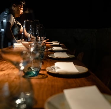 a man standing at a table with plates and glasses