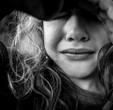 a kid with long hair snd tears and a black and white photo