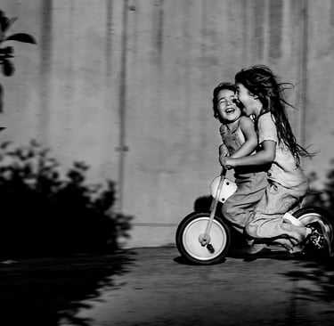 a little girl riding a tricycle in a black and white photo