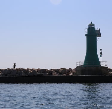 Paolo Corradeghini mentre cammina sulla diga foranea di La Spezia con un'antenna GNSS in mano