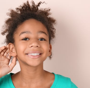 a young girl with a green shirt touching her ear