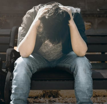 guy sitting on a park bench seemingly scared