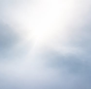 a plane flying through the sky with a sun shining through the clouds