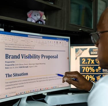 A marketing professional reviewing a digital brand visibility proposal on a computer monitor.
